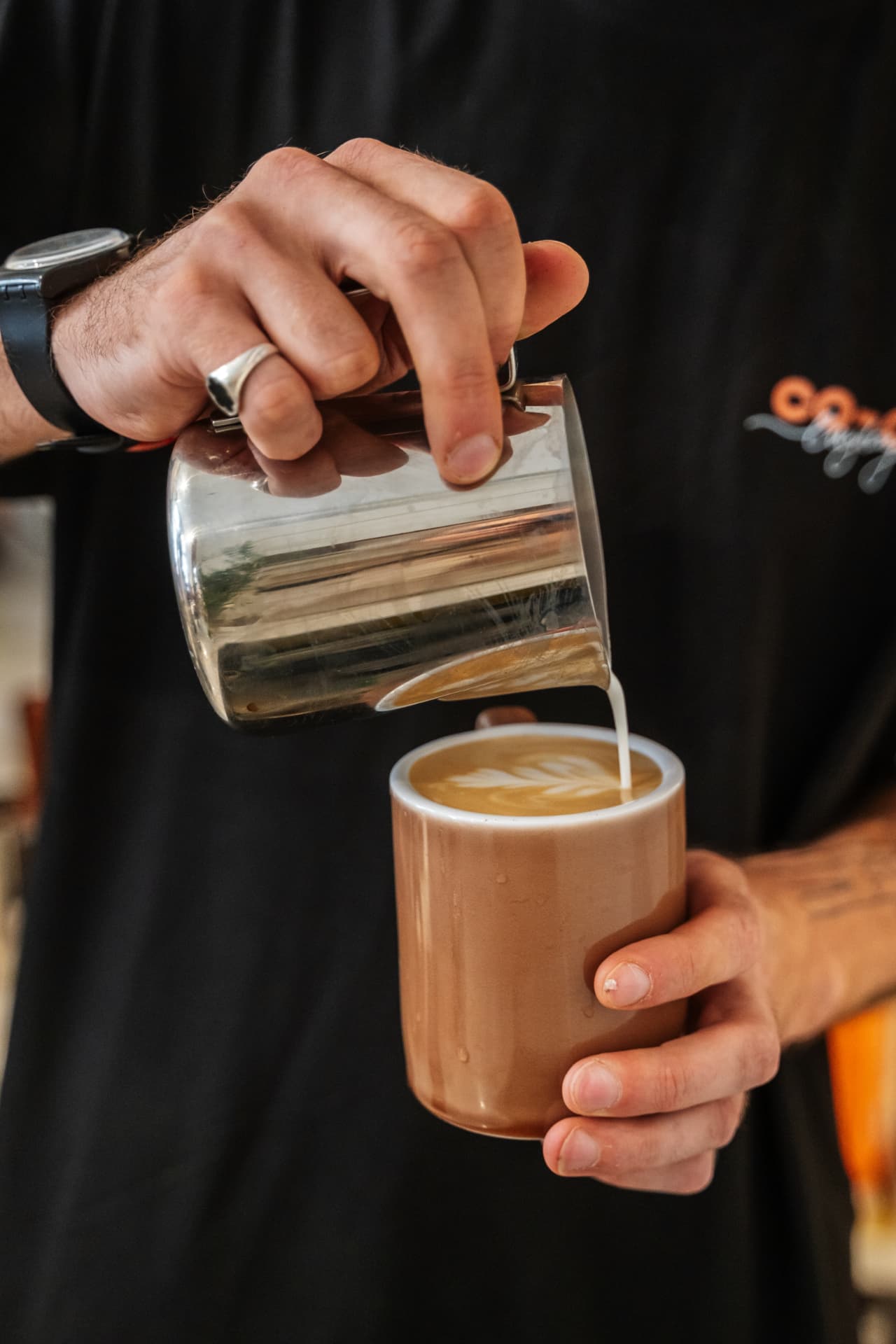 Barista pouring a flat white